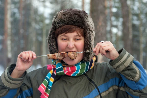 Девушка ест шашлык — стоковое фото