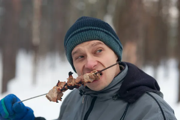 De man eet een shish kebab — Stockfoto