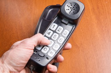 Wired office phone in men's hand clipart
