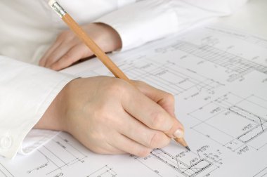 Hand with pencil drawing construction plan clipart