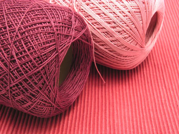Due palline di lana su fondo rosso — Foto Stock