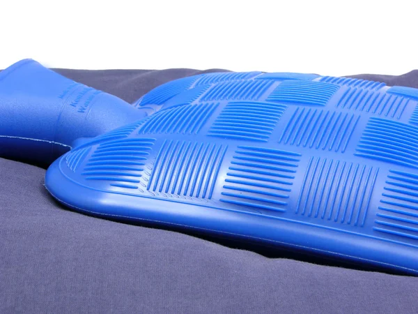 Niebieska torba na gorącą wodę na niebieskiej poduszce — Zdjęcie stockowe