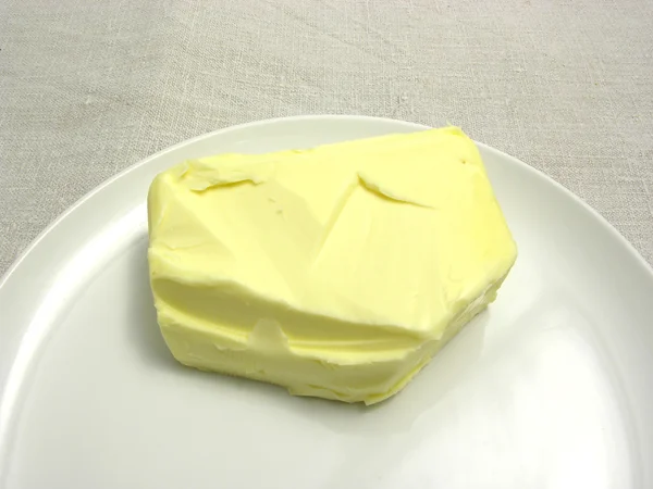 Beurre placé sur une assiette ronde disposée sur un napperon — Photo
