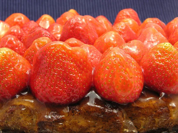 Lateral close-up view of a strawberry cake on blue background — Stock Photo, Image
