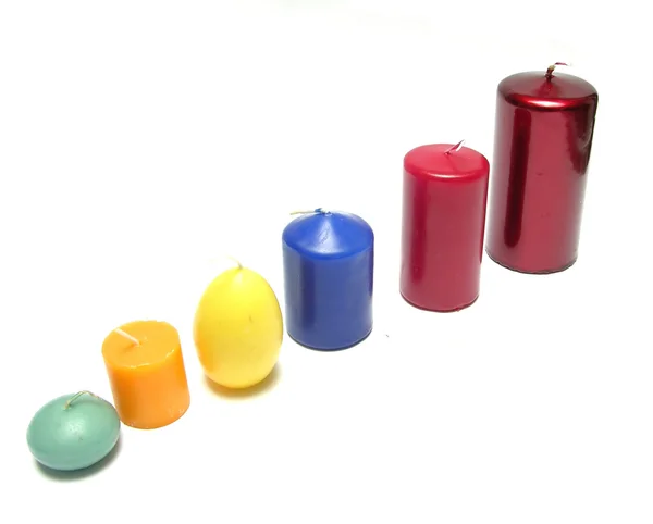 Six different coloured candles in a line — Stock Photo, Image