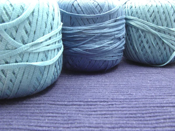 Tres bolas de lana azul para la costura dispuestas en un mantel azul —  Fotos de Stock