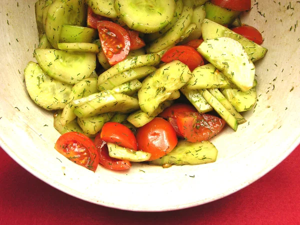 Komkommers en tomaten met salat dressing in een kom met keramiek — Stockfoto