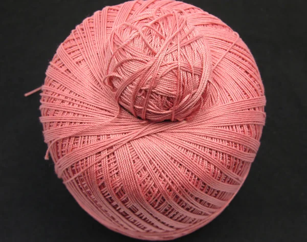 Bolas cor-de-rosa de lã sobre um fundo preto — Fotografia de Stock