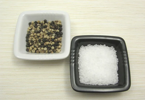 Bol de chinaware aux grains de poivre et sel sur sous-couche beige — Photo