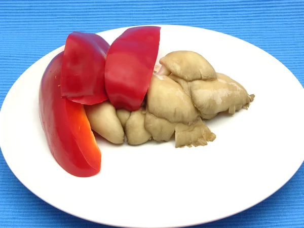 Грибы устрицы и красный перец на белой тарелке фарфора — стоковое фото