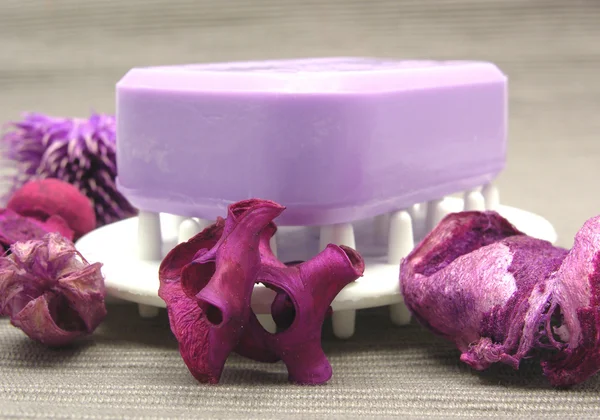 Jabón lila con artículos de decoración sobre fondo gris — Foto de Stock