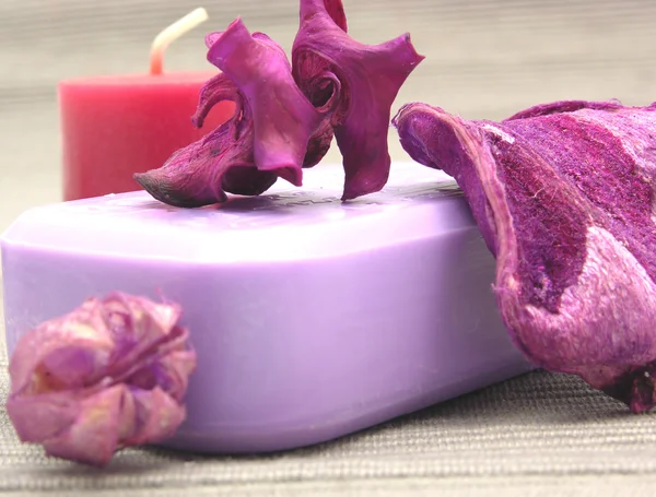 Jabón lila con artículos de decoración sobre fondo gris —  Fotos de Stock