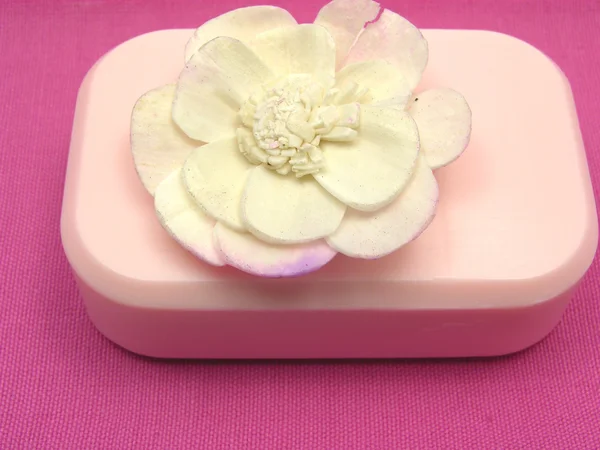 Jabón rosa con artículos de decoración sobre fondo rosa —  Fotos de Stock
