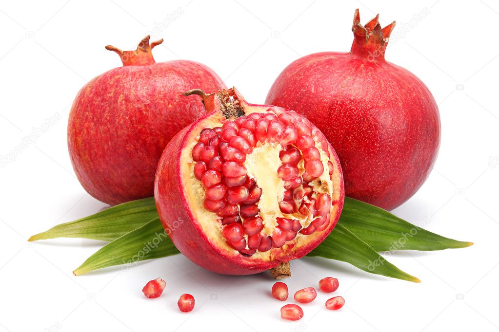 Pomegranate fruits with green leaf and cuts isolated