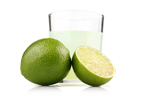 Glass of lime juice and lime fruits with slices isolated — Stock Photo, Image