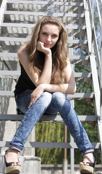 Bastante encantadora chica morena sentada en las escaleras —  Fotos de Stock