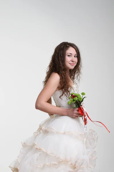 Улыбающаяся невеста в свадебном платье с букетом — стоковое фото