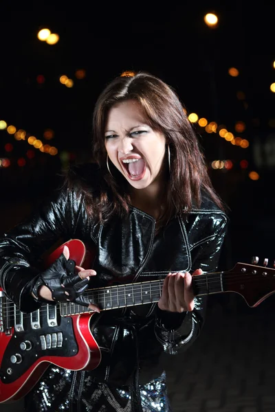 Brunettte gitarr spelare flicka i natt — Stockfoto