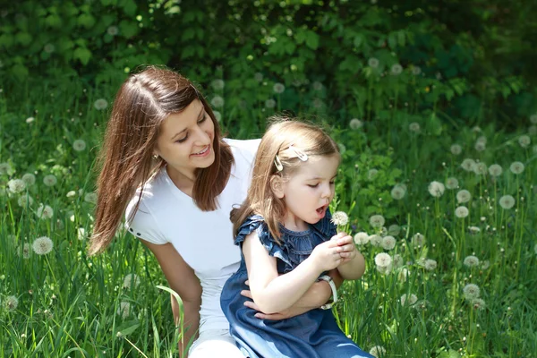 Two girls on the glade with dandelions — Stock Photo, Image