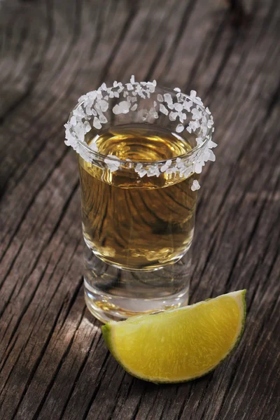 stock image One tequila shot and lime on the wooden background. Close up