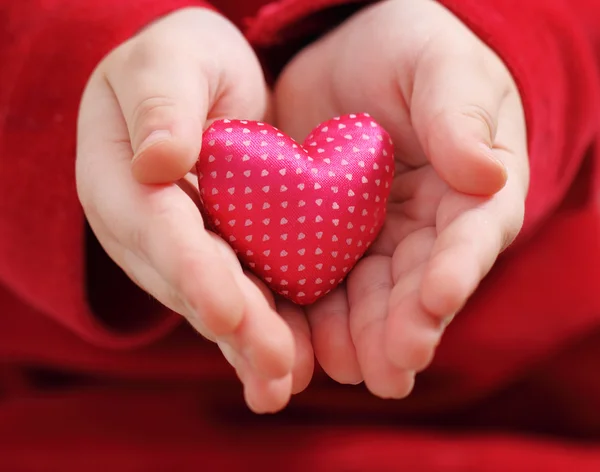 Child holds satin valentine heart — Stockfoto