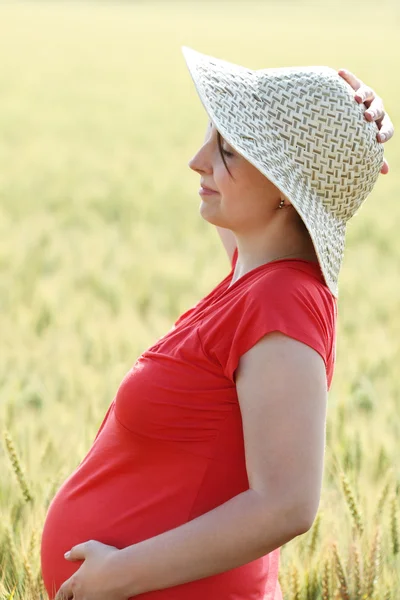 Šťastné těhotná žena v poli letní — Stock fotografie