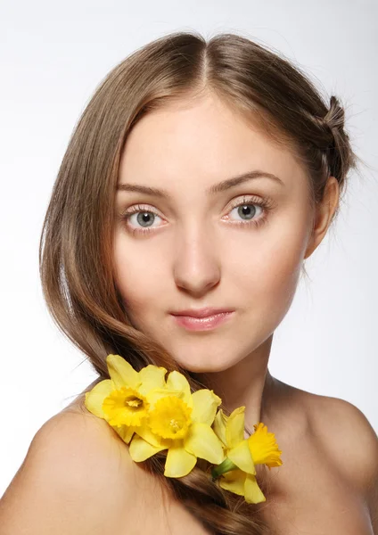 Blond tjej med blommor i håret — Stockfoto