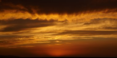 Storm clouds and sunset over mountains clipart