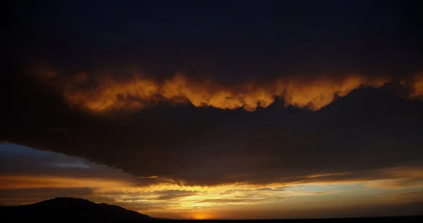 Nubes de tormenta y puesta de sol sobre montañas —  Fotos de Stock