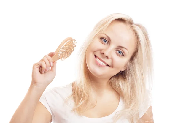 Schöne junge blonde Frau beim Bürsten ihrer langen Haare — Stockfoto