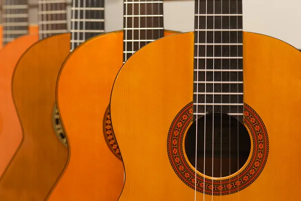 Rij van klassieke akoestische gitaren in muzikale winkel. Close-up vie Rechtenvrije Stockafbeeldingen