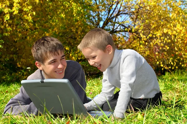 Teenager and kid with notebook — Stock Photo, Image
