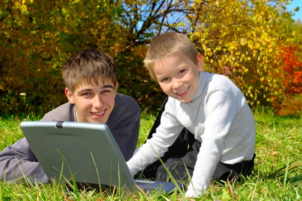 Teenager and kid with notebook — Stock Photo, Image