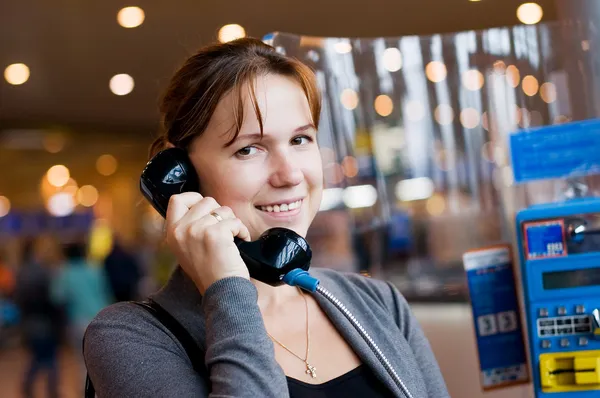 A menina fala por telefone no aeroporto — Fotografia de Stock