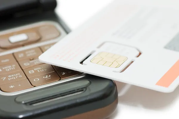Celular e cartão SIM isolado no fundo branco — Fotografia de Stock