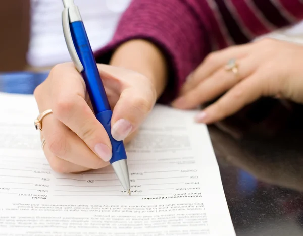 Kvinnliga händer med en penna skriva på ett papper — Stockfoto
