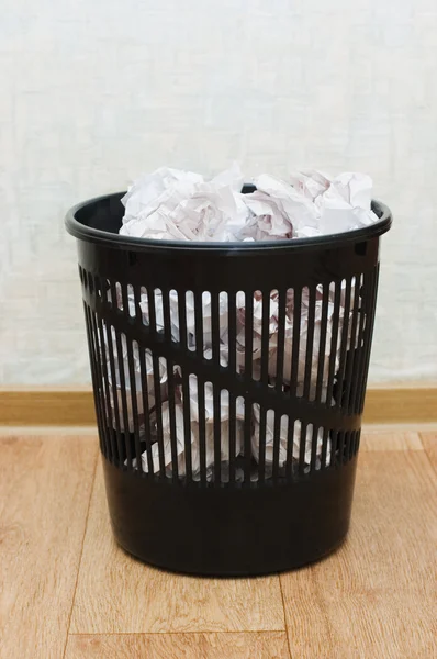 Black plastic basket with garbage indoors — Stock Photo, Image