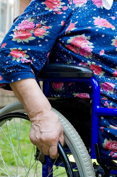 Hand der alten Frau auf einem ungültigen Sessel — Stockfoto