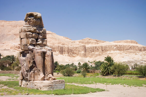 Статуя и колонна древнего фараона на подсветке неба
