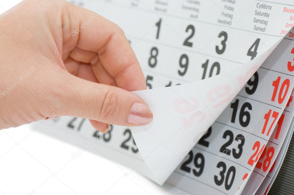 The hand overturns calendar sheet isolated on white background