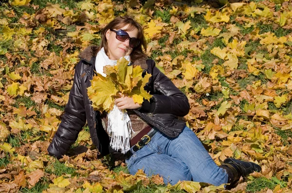 Το όμορφο κορίτσι με το φθινόπωρο τα φύλλα — Stockfoto