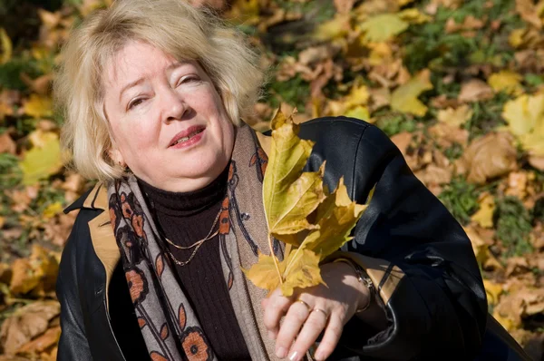 Die schöne Frau mit den Herbstblättern — Stockfoto
