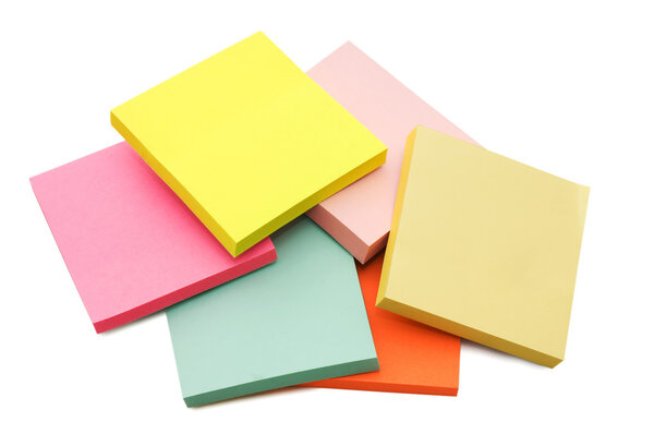Block of vibrant multicoloured Post it Notes isolated on white