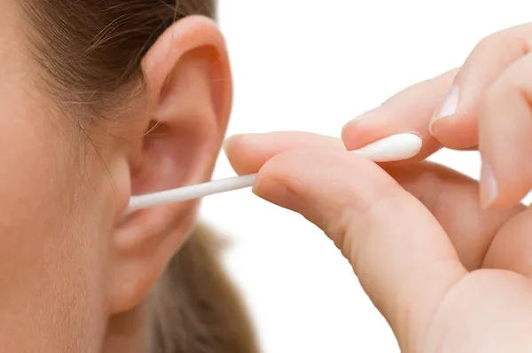 Una mujer limpiándose la oreja con hisopo de algodón —  Fotos de Stock