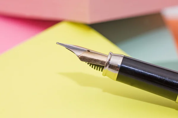 Фонтанная ручка и цветные ноты — стоковое фото