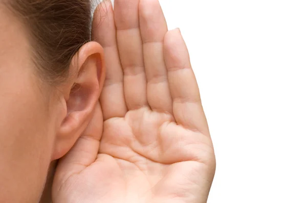 Meisje met haar hand op een oor te luisteren — Stockfoto