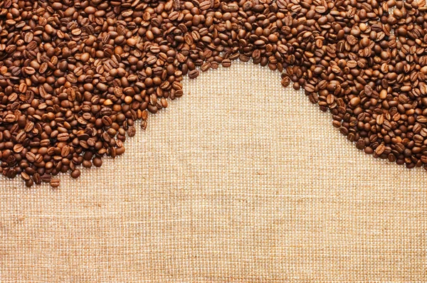 Brown coffee grains on a sacking — Stock Photo, Image