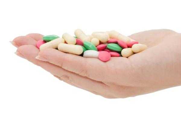 Hand med ett piller på vit bakgrund — Stockfoto