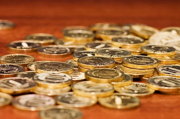 Gyllene mynt på ett träbord — Stockfoto