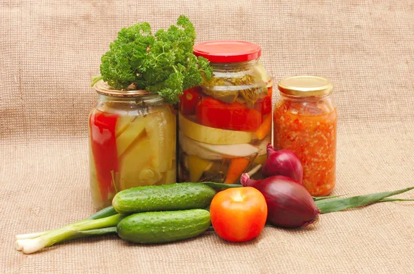 Fresh and tinned vegetables on a sacking — Stock Photo, Image